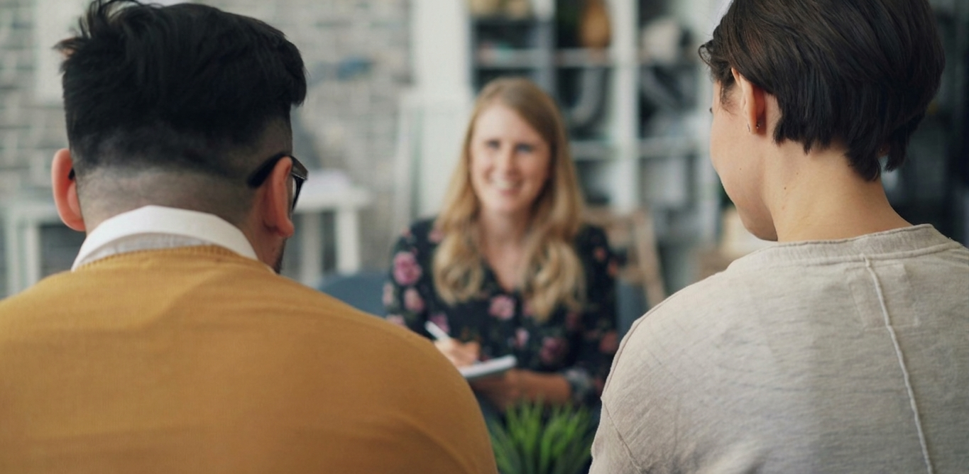 Two people facing a woman in an office setting